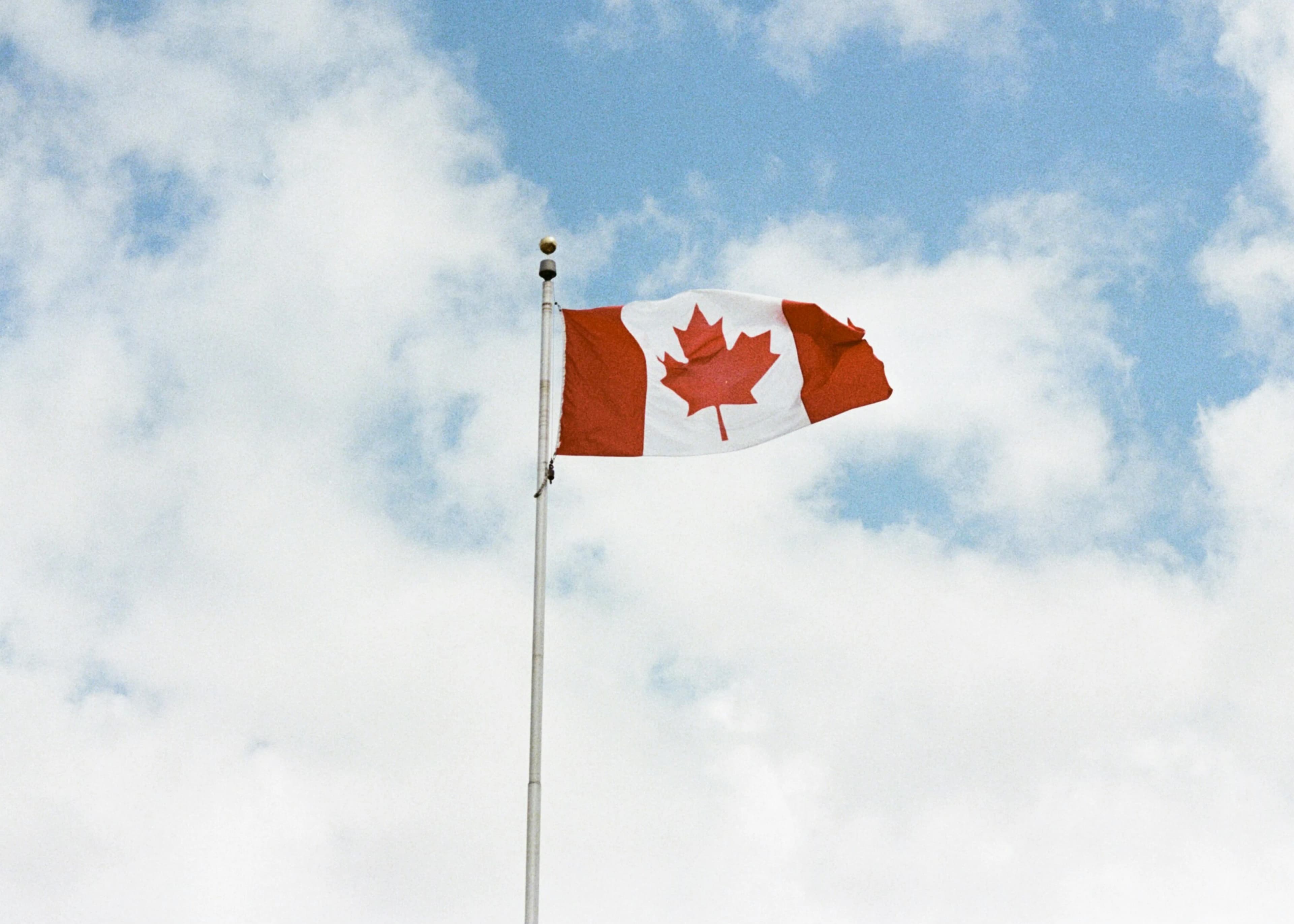 Canadian flag waving against a blue sky